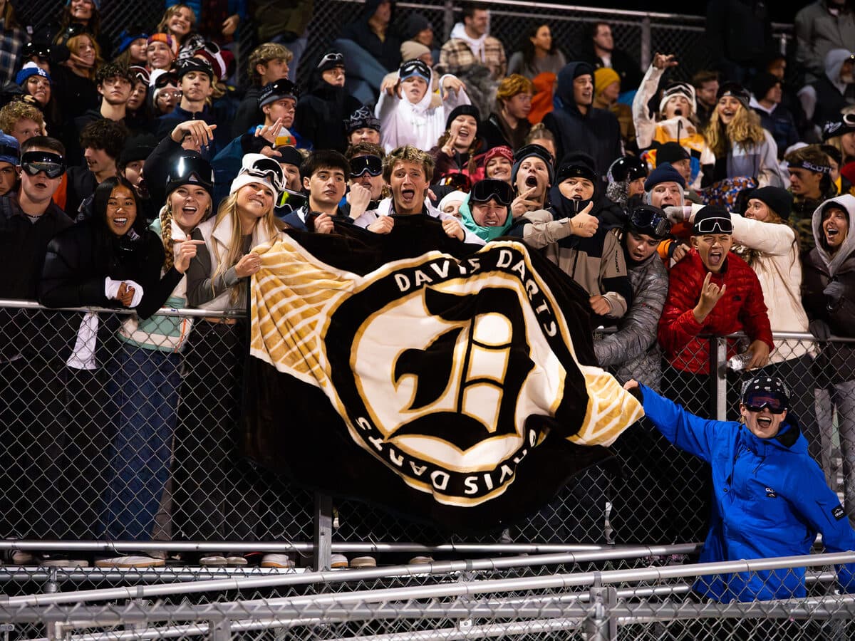 Student section holding a printed Lite Plus blanket overhead at a game